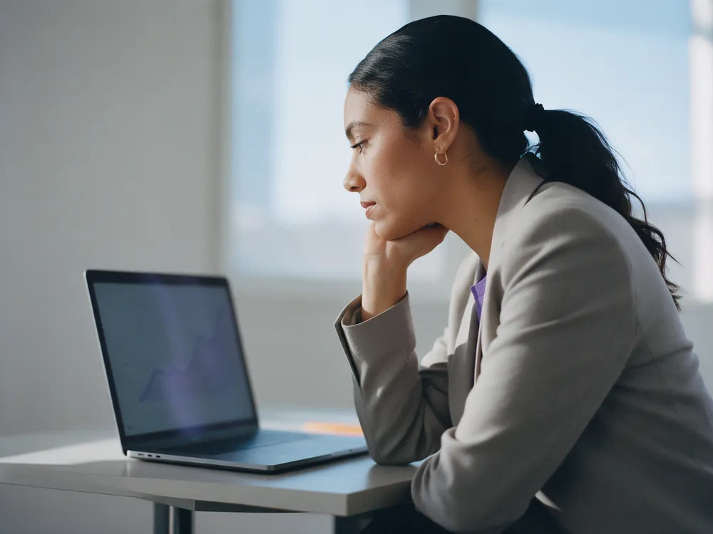 A marketer studying a rising ranking chart on her laptop